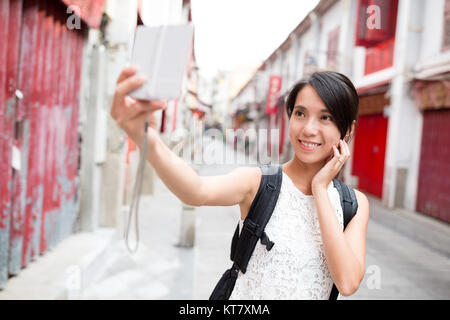 Donna prendendo foto da una fotocamera digitale a Macao città vecchia Foto Stock