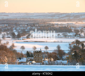 Bourton su per la collina e la campagna circostante nella neve e nebbia a sunrise in dicembre. Bourton sulla collina, Cotswolds, Gloucestershire, Inghilterra Foto Stock