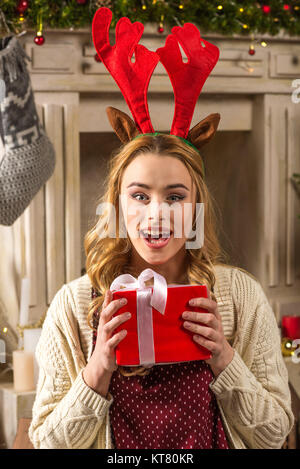 Sorpreso donna tenendo presente di natale Foto Stock