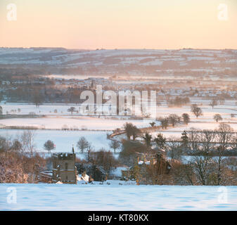 Bourton su per la collina e la campagna circostante nella neve e nebbia a sunrise in dicembre. Bourton sulla collina, Cotswolds, Gloucestershire, Inghilterra Foto Stock