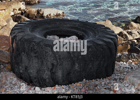 Grande carrello pneumatico a sinistra sulla spiaggia. Isolato closeup. Foto Stock