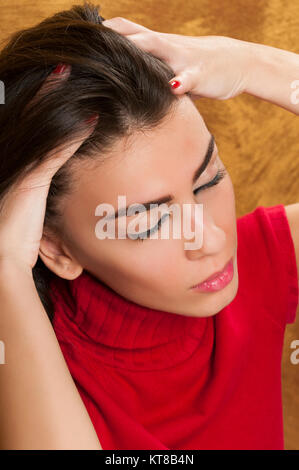 Sottolineato giovane donna di graffiare la testa Foto Stock