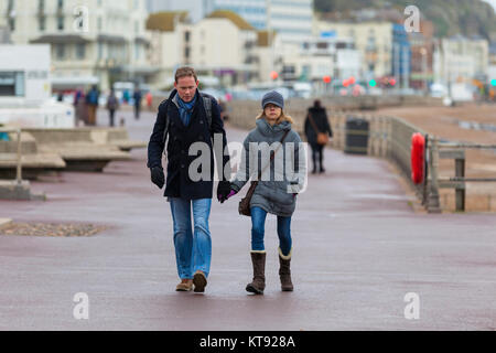Hastings, East Sussex, Regno Unito. 23 Dic, 2017. Un giovane tenere le mani mentre si cammina lungo la passeggiata sul lungomare. Photo credit: Paolo Lawrenson/Alamy Live News Foto Stock