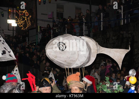 Mousehole, Cornwall, Regno Unito. Il 23 dicembre 2017. Tom Bawcocks Eve. Il leggendario Tom Bawcock salvato il villaggio di Mousehole dalla carestia da andare a pescare in una violenta tempesta. Visto qui la locale scuola lantern parade. Credito: Simon Maycock/Alamy Live News Foto Stock