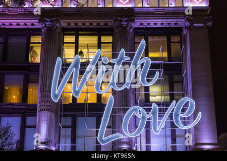 Oxford Street, Londra, 23 dic 2017. Dal grande magazzino Selfridges offre un 'con amore...dall' messaggio sulla sua facciata per il Natale. La sera prima della Vigilia di Natale, il clima mite ha portato migliaia di last minute shoppers, navigazione per occasioni e presenta, godendo le luci di Natale e passeggiando lungo i marciapiedi affollati. Credito: Imageplotter News e sport/Alamy Live News Foto Stock