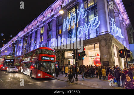 Oxford Street, Londra, 23 dic 2017. Dal grande magazzino Selfridges offre un 'con amore...dall' messaggio sulla sua facciata per il Natale. La sera prima della Vigilia di Natale, il clima mite ha portato migliaia di last minute shoppers, navigazione per occasioni e presenta, godendo le luci di Natale e passeggiando lungo i marciapiedi affollati. Credito: Imageplotter News e sport/Alamy Live News Foto Stock