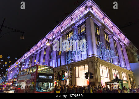 Oxford Street, Londra, 23 dic 2017. Dal grande magazzino Selfridges offre un 'con amore...dall' messaggio sulla sua facciata per il Natale. La sera prima della Vigilia di Natale, il clima mite ha portato migliaia di last minute shoppers, navigazione per occasioni e presenta, godendo le luci di Natale e passeggiando lungo i marciapiedi affollati. Credito: Imageplotter News e sport/Alamy Live News Foto Stock