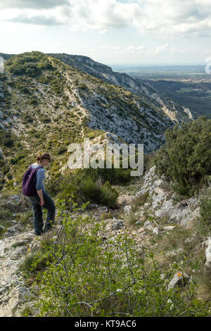 Giovane donna a piedi lungo un crinale montuoso ad Alpilles, vicino a Saint Remy de Provence, Francia Foto Stock
