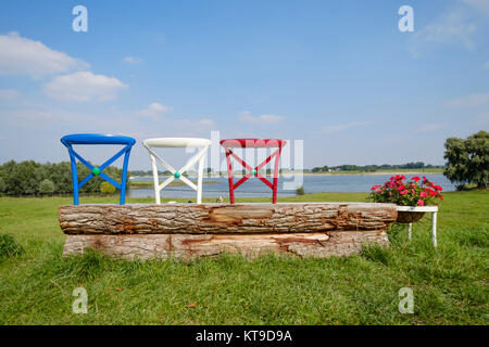 Armonici panchina da giardino costituito da un tronco di albero e di uno schienale di sedie dipinte in colori diversi Foto Stock