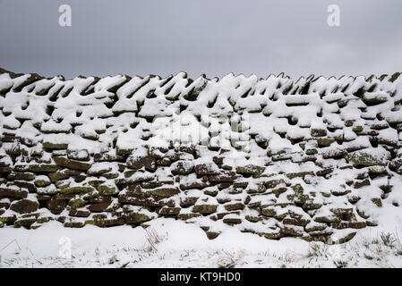 Stalattite tradizionale parete ricoperta di neve. Il Peak District, Derbyshire, in Inghilterra. Foto Stock