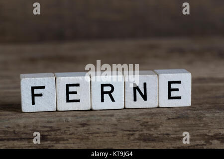 Parola tedesca distanza, scritto in cubi su uno sfondo di legno Foto Stock