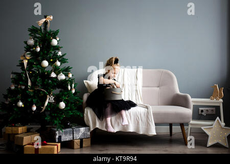 Bambina decora un albero di Natale. Buon Natale e Buone Feste. Foto Stock