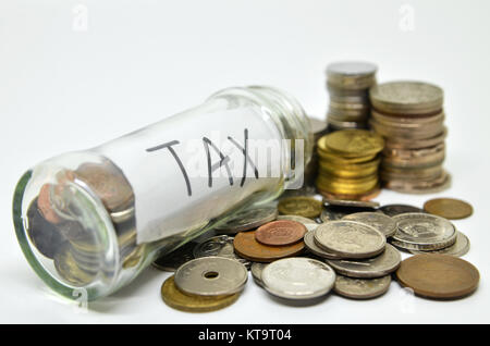 Etichetta fiscale in un vasetto di vetro con monete fuoriuscita Foto Stock