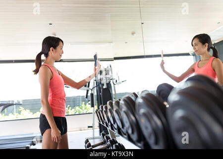 Donna prendendo selfie in palestra Foto Stock