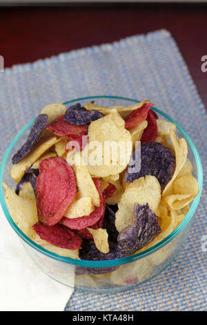 Colorato Potato Chips in una ciotola trasparente Foto Stock