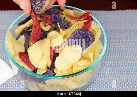 Dita la scelta di rosso, di porpora e giallo Potato Chips Foto Stock