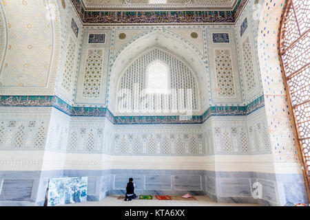 Un uomo musulmano prega nel Bibi Khanym moschea, Samarcanda, Uzbekistan Foto Stock