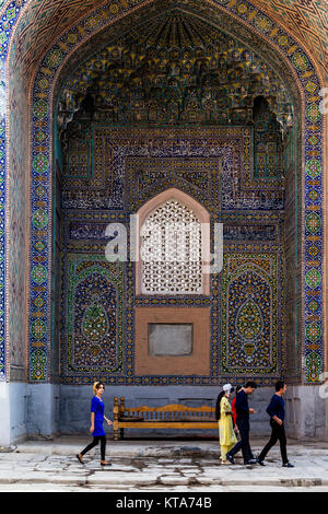 Giovani visitatori uzbeko all'interno della Sher Dor Madrassa, Il Registan, Samarcanda, Uzbekistan Foto Stock