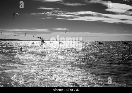 Cumbuco, Brasile, lug 9, 2017: visualizzazione bianco e nero del kite surfers godendo il mare al tramonto Foto Stock