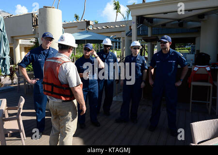 Coast Guard CDR. Tedd Hutley, Incident Commander per il supporto di emergenza funzione 10 Risposta, Golfo Strike Team comandante, discute le operazioni con Chief Warrant Officer Bridgette Brown, vice direttore di filiale per San Giovanni, Mike Jarvis, risolvere Marine Group, Sottufficiali di prima classe Kenneth Freeman, Pacific Strike Team, Chief Petty Officer Isacco Chavalia, Golfo Strike Team, e il tenente Rafael Shamilov, Pacific Strike Team in Great Cruz Bay, Dic 20, 2017. I membri della FSE-10 sollevamento risposta barche, patch e dare loro torna ai proprietari come parte di una speciale considerazione il programma a Foto Stock