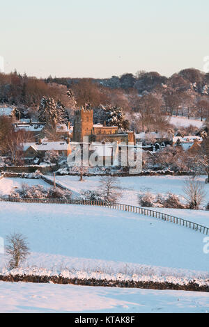 Saint Lawrence chiesa in Bourton sulla collina nella neve a sunrise in dicembre. Bourton sulla collina, Cotswolds, Gloucestershire, Inghilterra. Foto Stock