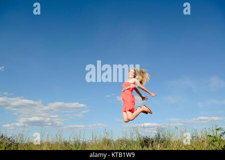 Frau macht Freudensprung Foto Stock