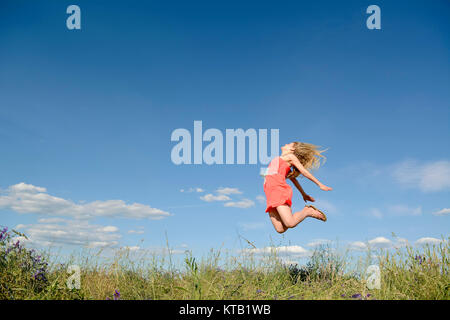 Frau macht Freudensprung Foto Stock