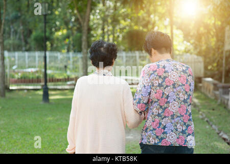 Vista posteriore asiatiche donne anziane passeggiate nel parco all'aperto Foto Stock