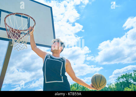 Giovane giocare a basket Foto Stock