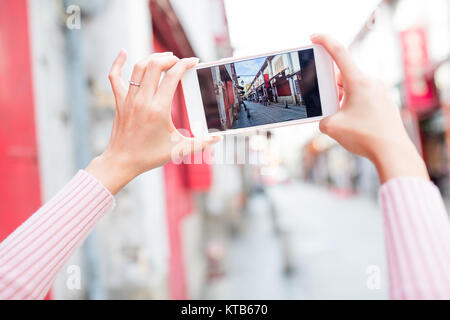 Donna prendendo foto sul cellulare a Macau Foto Stock