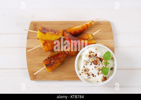 Pera e arancia spiedini con yogurt dip Foto Stock