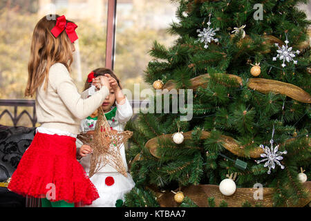 Sorelle decorare l'albero di Natale Foto Stock