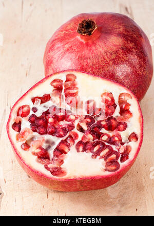 Frutto del melograno rosso sul ceppo di legno, vicino. Foto Stock
