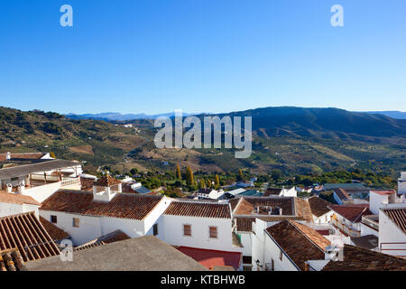 Le case bianche di casarabanela Andalusia spagna con orange tegole sul tetto che si affaccia su uno scenario di montagna verso malaga sotto un cielo blu chiaro Foto Stock