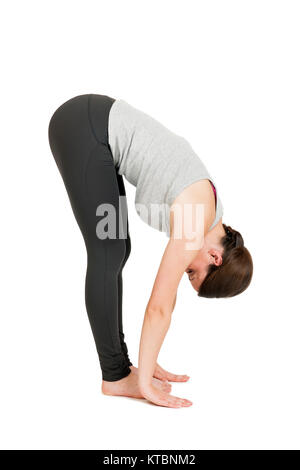 Ganzkörper-Ansicht einer jungen schwarzhaarigen Frau bei Yoga-Übung 'Stehende Vorbeuge' Passo 3 vor weißen Hintergrund mit leichtem Schatten Foto Stock