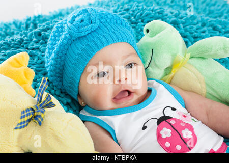 Quattro mesi bambina indossa un tappo blu Foto Stock