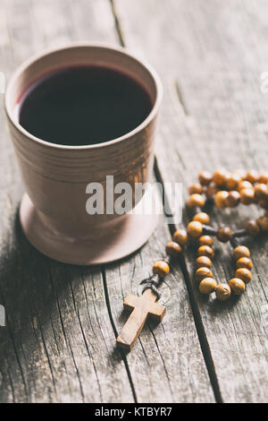 I grani del rosario e bicchiere di vino. Foto Stock