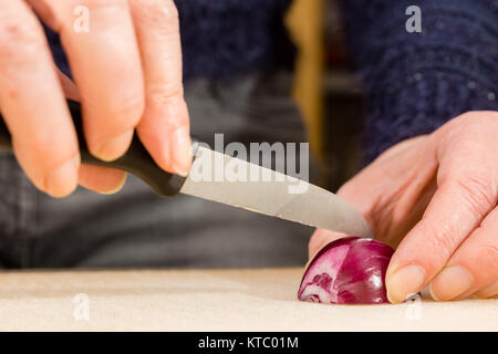 Hausfrau beim Schneiden einer roten Zwiebel Foto Stock