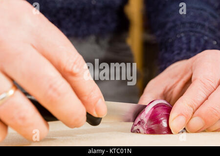 Hausfrau beim Schneiden einer roten Zwiebel Foto Stock