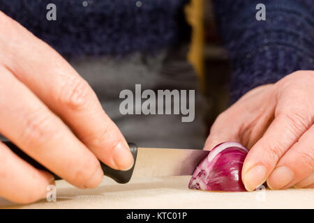 Hausfrau beim Schneiden einer roten Zwiebel Foto Stock