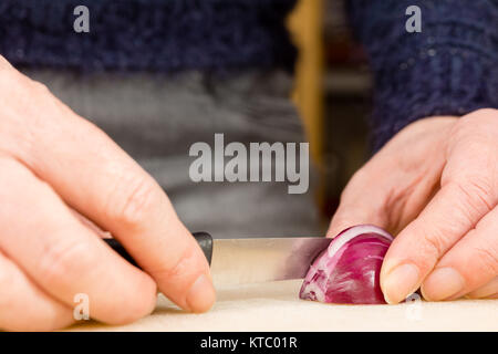 Hausfrau beim Schneiden einer roten Zwiebel Foto Stock