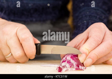 Hausfrau beim Schneiden einer roten Zwiebel Foto Stock