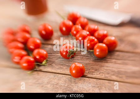 Kleine Rispentomaten auf einem Holzbrett Foto Stock