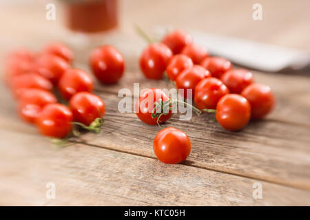 Kleine Rispentomaten auf einem Holzbrett Foto Stock