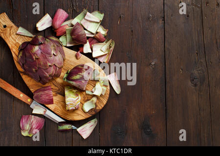 Carciofi romani su una tavola di legno Foto Stock