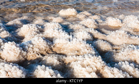 Il sale di mare sulla spiaggia del Mar Morto nella soleggiata giornata invernale Foto Stock