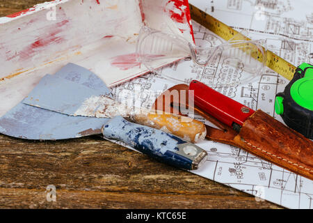 Set di cerotti assortiti strumenti e spatola su sfondo di legno vecchio. Costruzione e ristrutturazione del concetto. Foto Stock