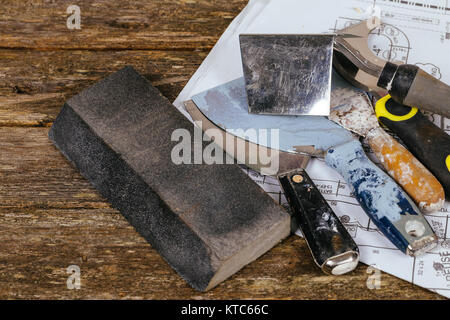 Costruzione e ristrutturazione concetto e set di gesso attrezzi cazzuola e spatola su legno di sfondo Foto Stock