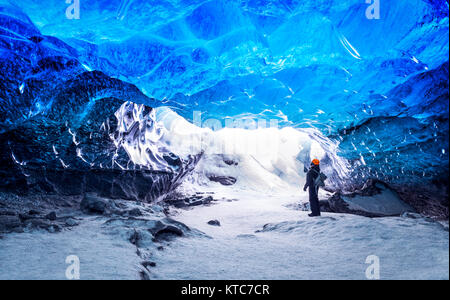 Traveler in caverna di ghiaccio, uomo metropolitana permanente all interno di un ghiacciaio, clima specifico, Vatnajokull National Park, natura straordinaria di Skaftafell, Islanda Foto Stock