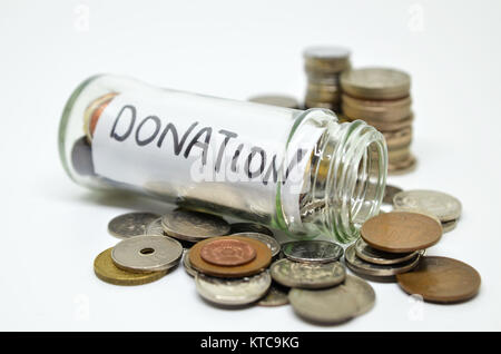 Etichetta di donazione in un vasetto di vetro con monete fuoriuscita Foto Stock